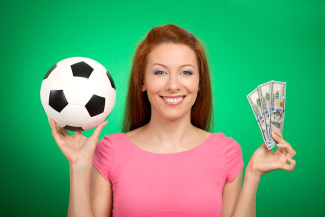 Frau lacht mit Ball und Geld in der Hand