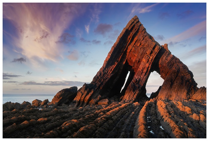 Blick auf Bdie beeindruckenden Felsformationen von Blackchurch Rock rötlich angestrahlt im Sonnenuntergang