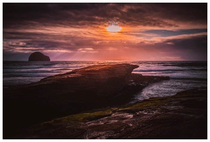 Blick auf die Felsen im Ozean bei Trebarwith Beach zum Sonnenuntergang
