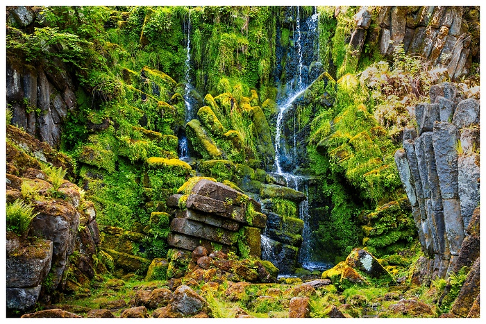 Blick auf einen wunderschönen Wasserfall mit interessanten Steinformationen im Bergpark Wilhelmshöhe in Kassel