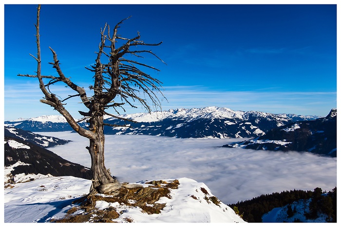 Blick von oben auf eine dichte Wolkenschicht, die das Tal verdeckt