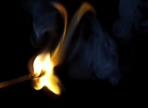 A match was lit and burns with a bright glow.