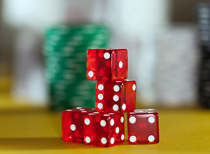 Five red-glowing, semi-transparent dices on a poker table