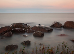 Stones in the water with red sunset at the Baltic Sea.