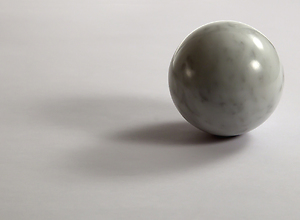 A bright marble ball is lying on the table, interesting shadows.
